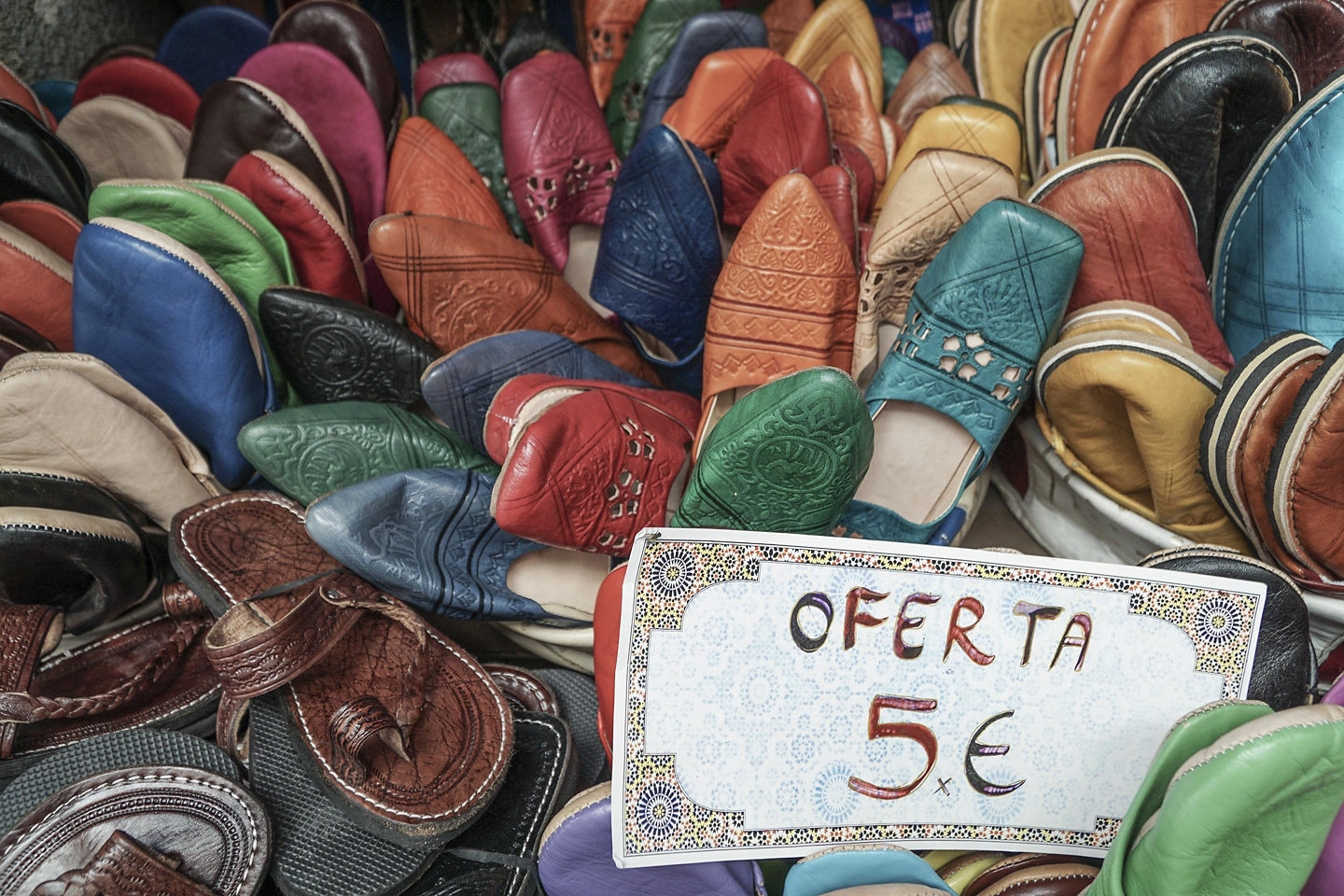 Alicante market stall displays rows of handcrafted leather shoes in warm, earthy tones. - Alicante, Spain