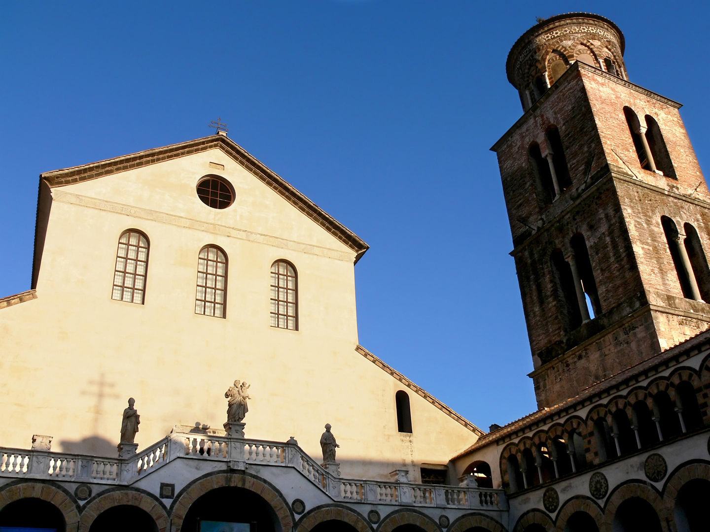 Amalfi Cathedral’s striped façade and arched entry rise above the square in warm daylight. - Barcelona, Spain