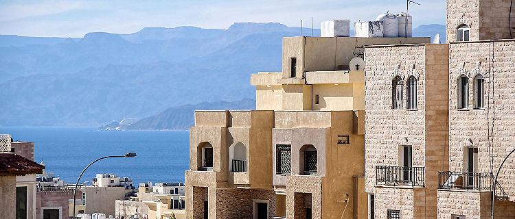 Typical Aqaba buildings on the foreground. the Gulf of Aqaba and mountains on the background