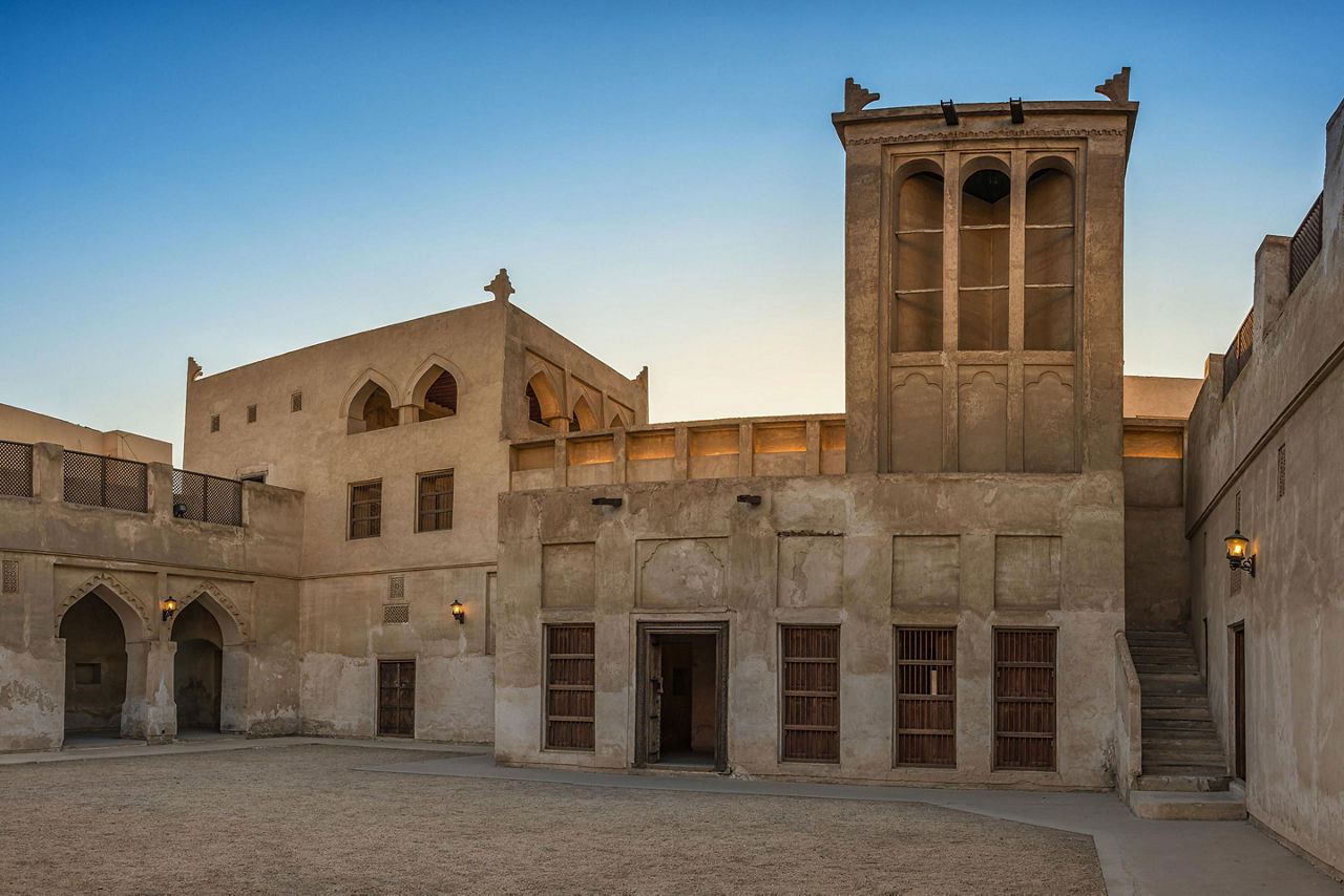 The wind-catcher tower at sunset over a courtyard of the restored traditional Arabian house of pearl trader Shaikh Isa bin Ali, in Bahrain