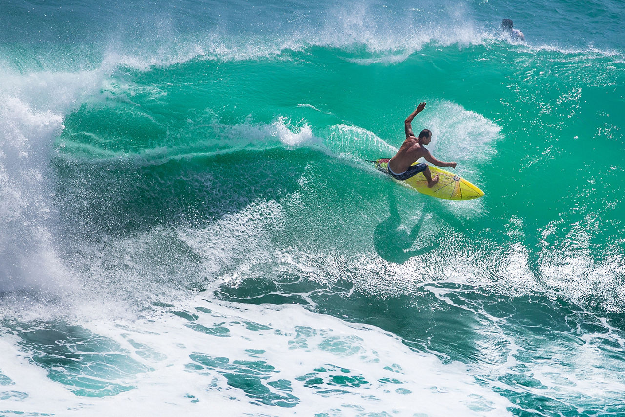 Surfer Riding a Big Wave at Padang Padang Beach, Bali, Indonesia.