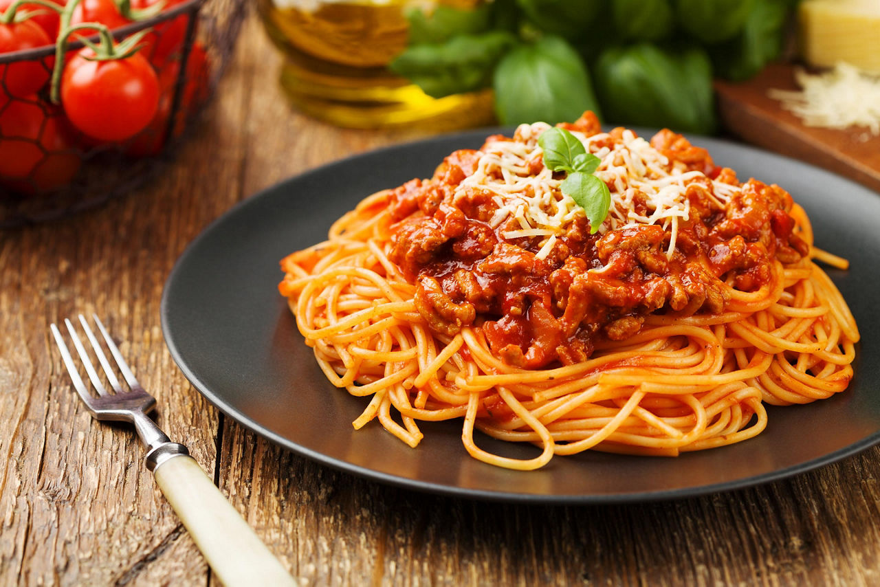 Delicious spaghetti bolognese served on a black plate in Bologna, Italy