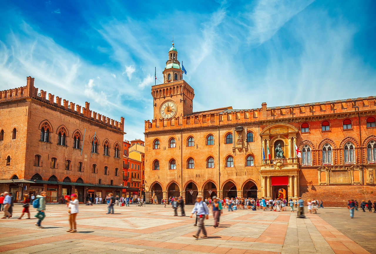 Piazza Maggiore with big clock and blue sky in Bologna, Italy