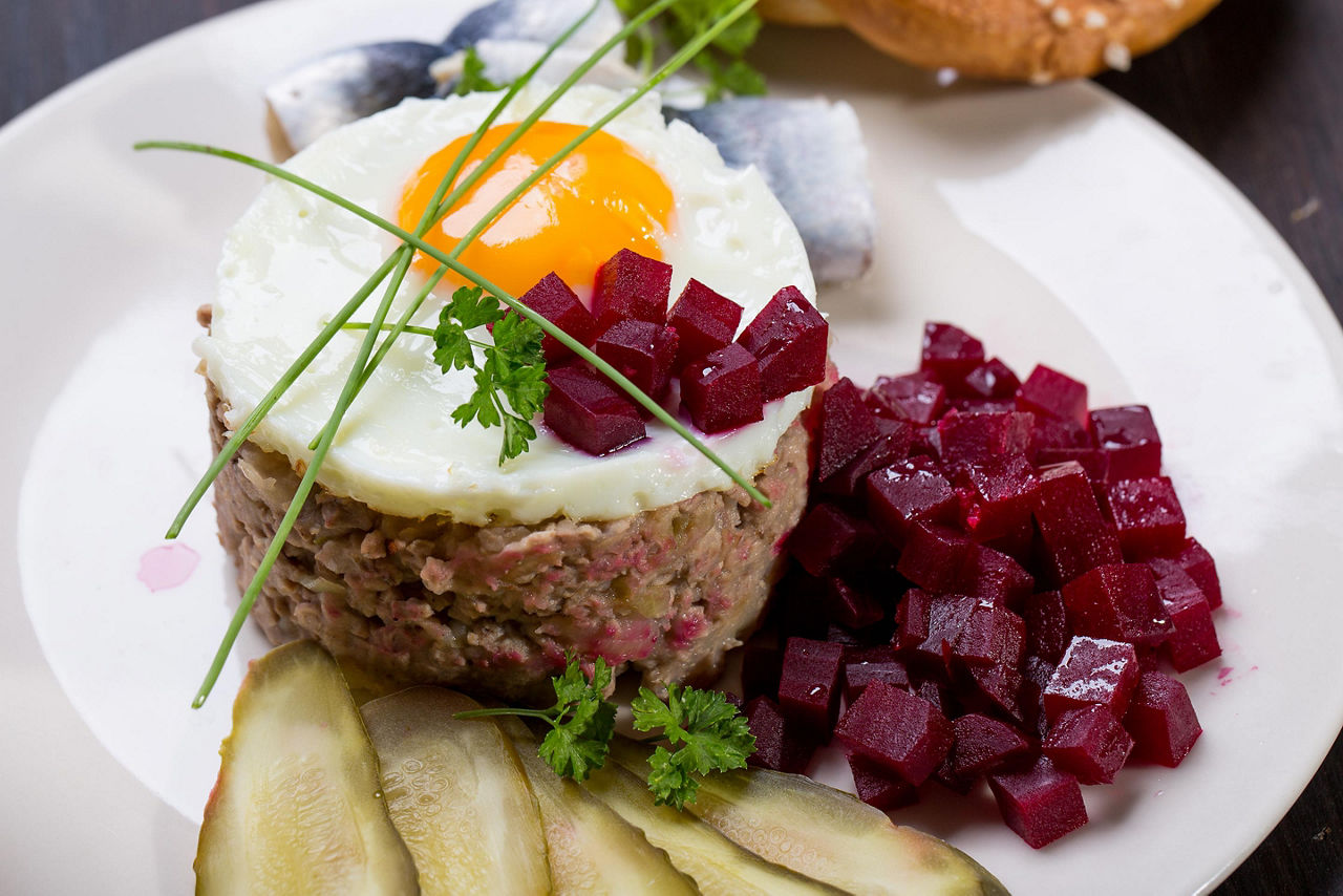 Traditional German labskaus seasoned meat, with a fried egg on top, and beetroots on the side, from a restaurant in Bremerhaven, Germany