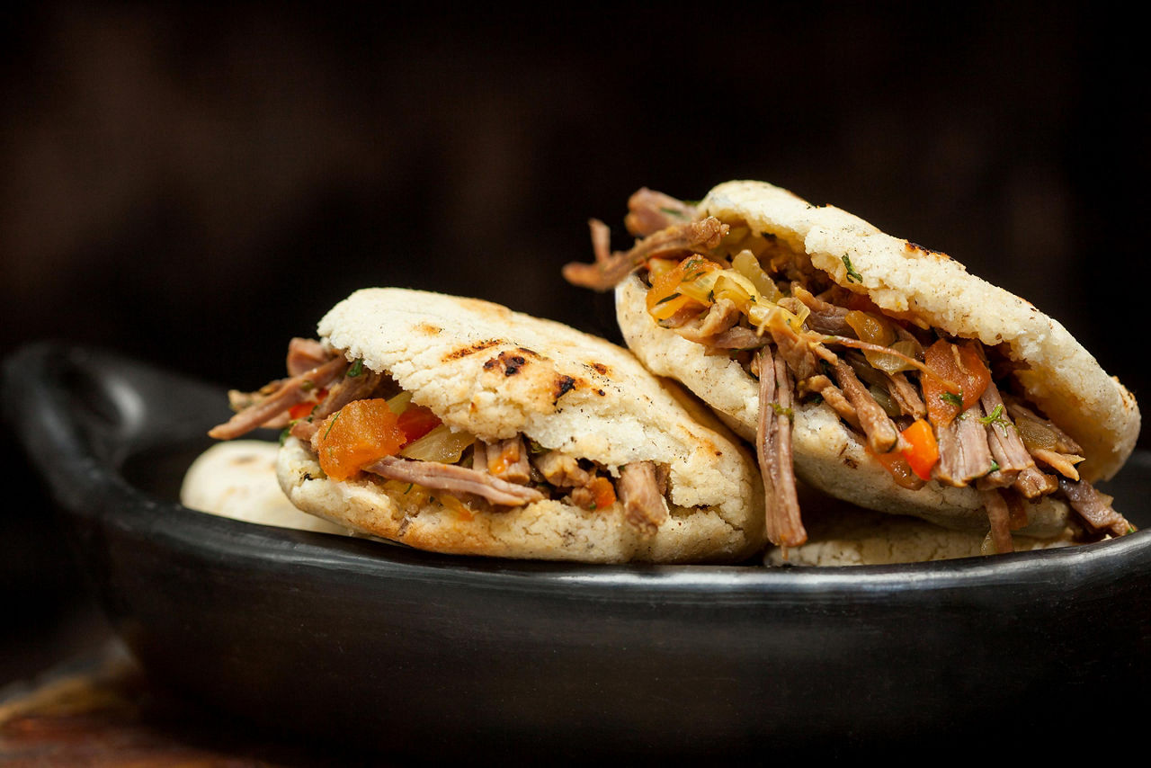 Two arepas rellenas filled with shredded beef