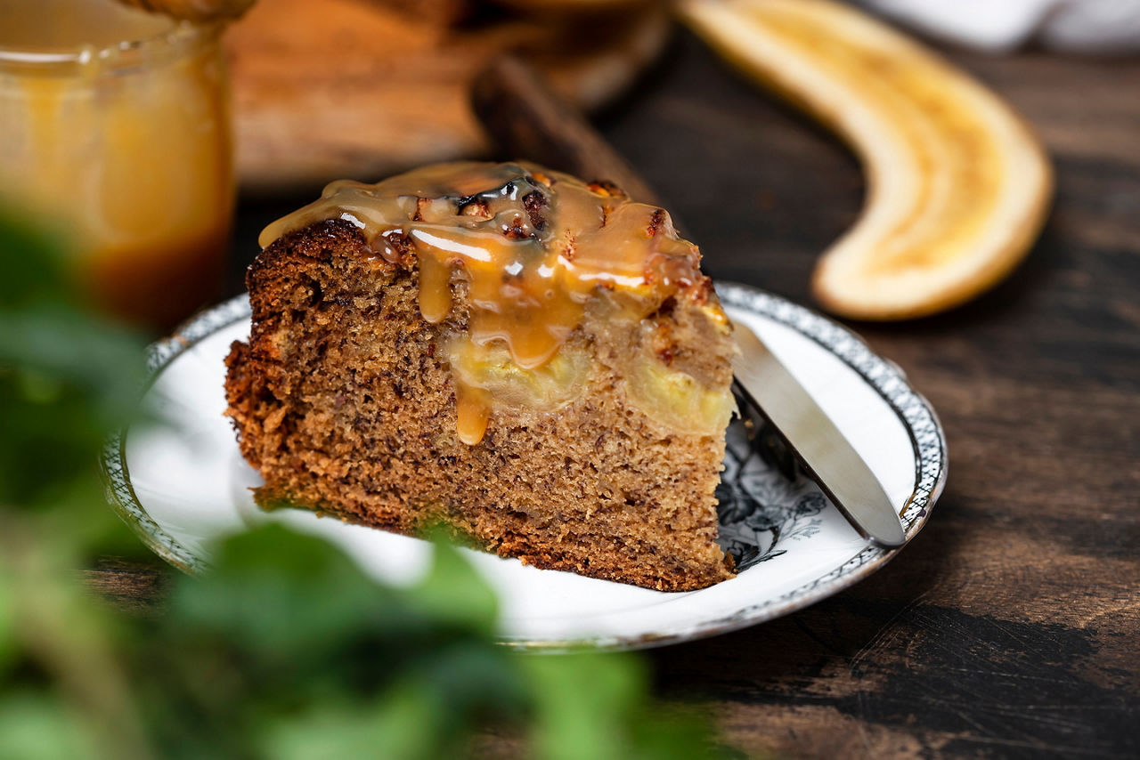 Upside down banana cake with caramel on a wooden table