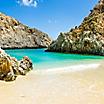 A beautiful pristine beach surrounded by rock formations in Crete
