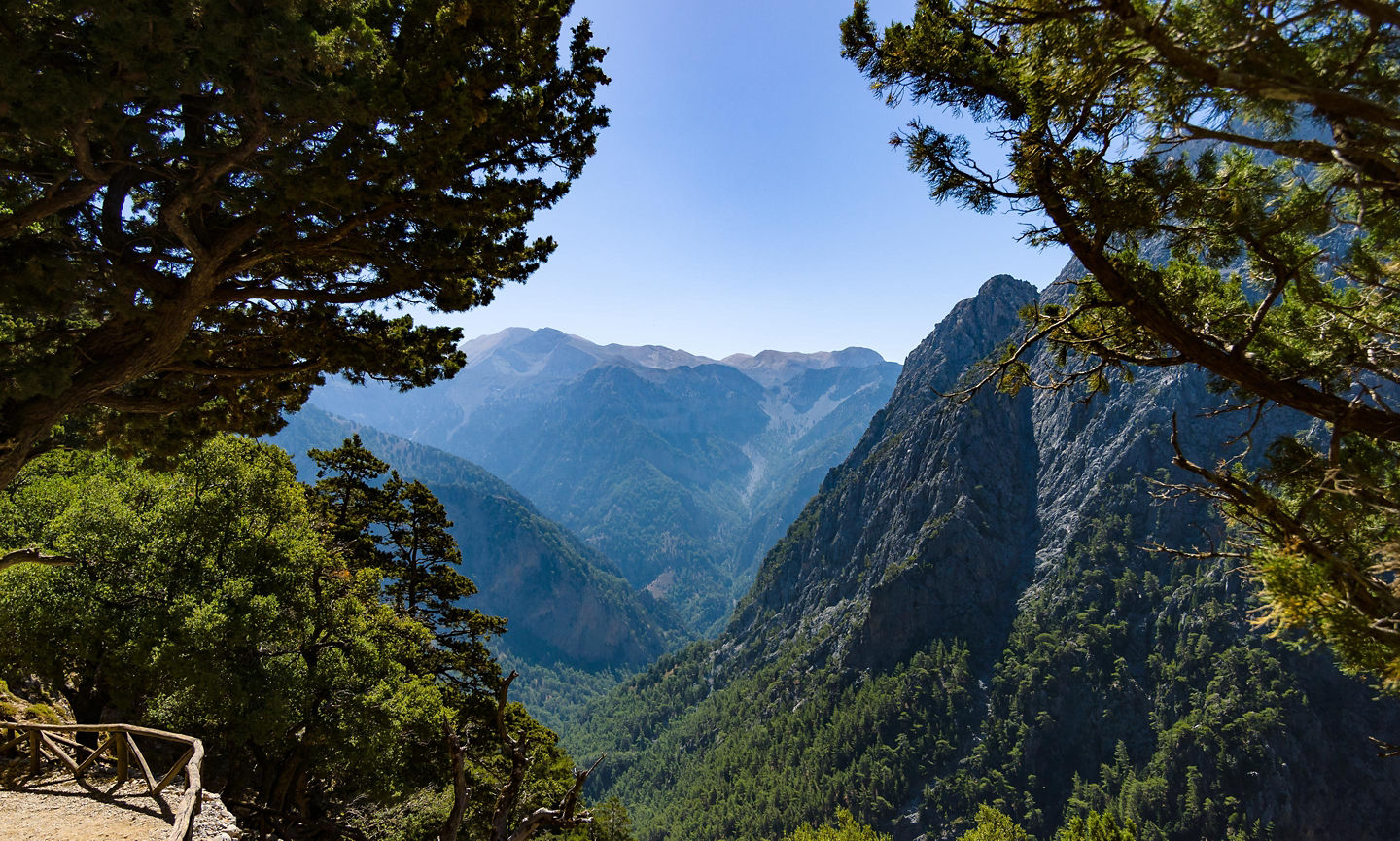Hikers walk through Samaria Gorge’s towering cliffs and rugged, sunlit rock walls on Crete. - Chania, Crete