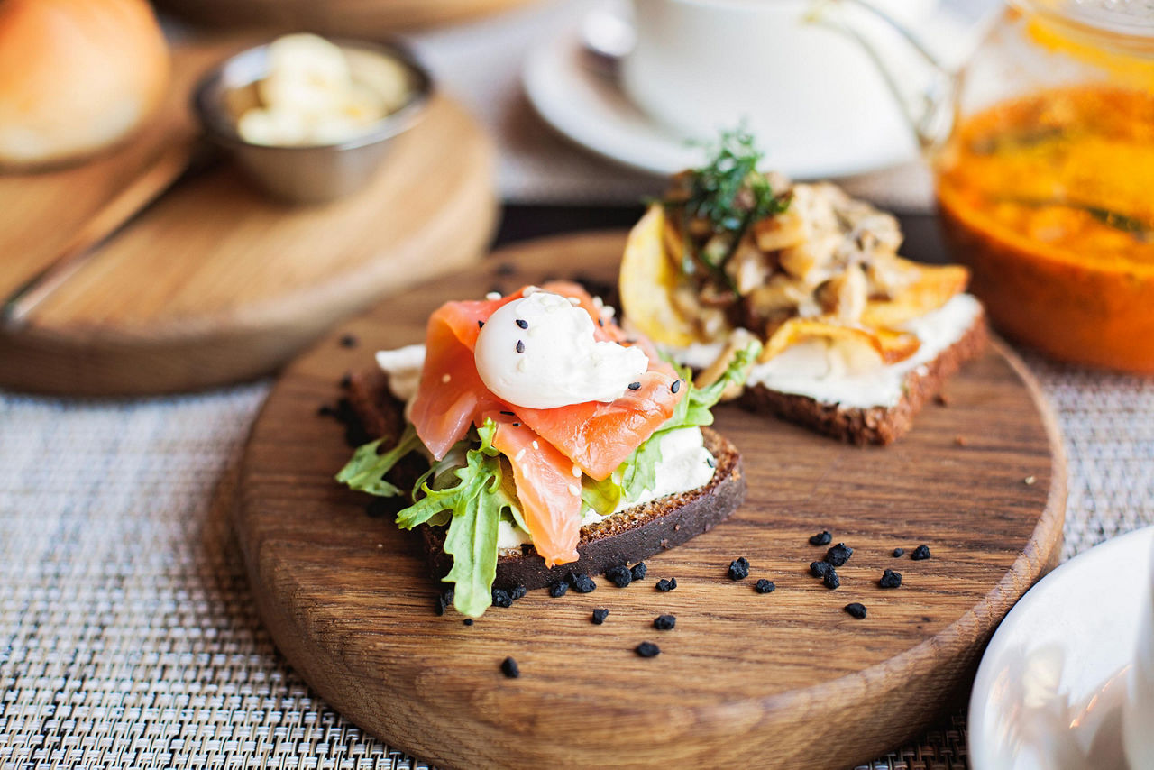Danish smørrebrød sandwich with salmon fish and egg on wooden board, in Copenhagen, Denmark