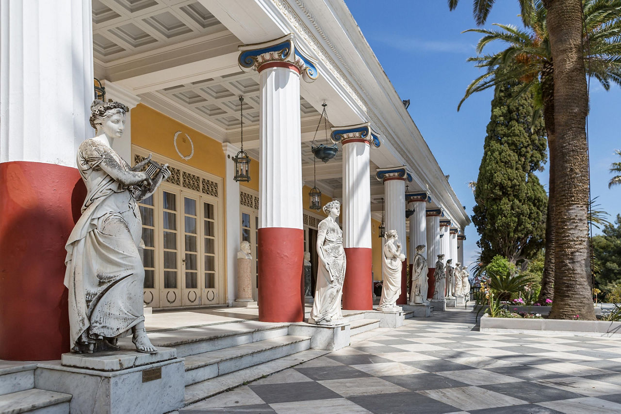 Statues in front of the pillars of the Achillion Palace in Corfu, Greece