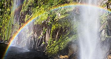 A rainbow shining over a waterfall in New Zealand