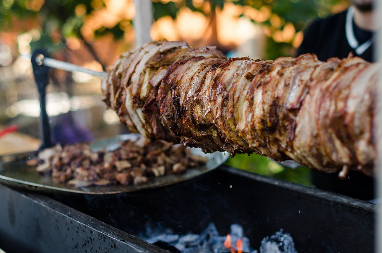 Cooking grilled meat shawarma to make hot kebabs, a typical street food in Dubai