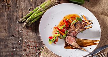 Lamb chops with vegetables served over a white plate