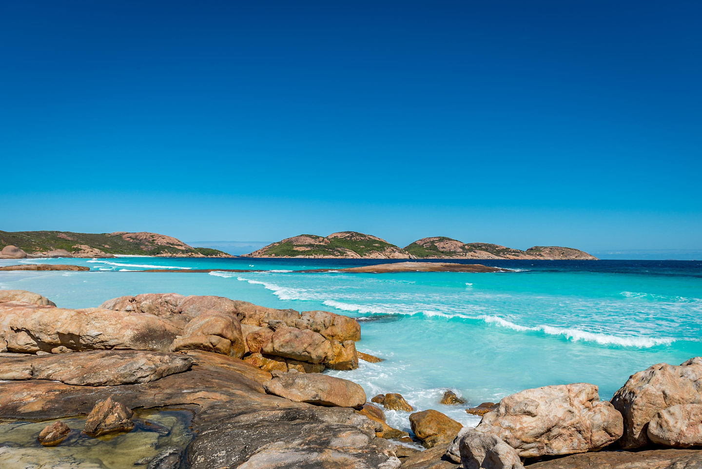 Lucky Bay with white sand, turquoise water, and rocky headland.