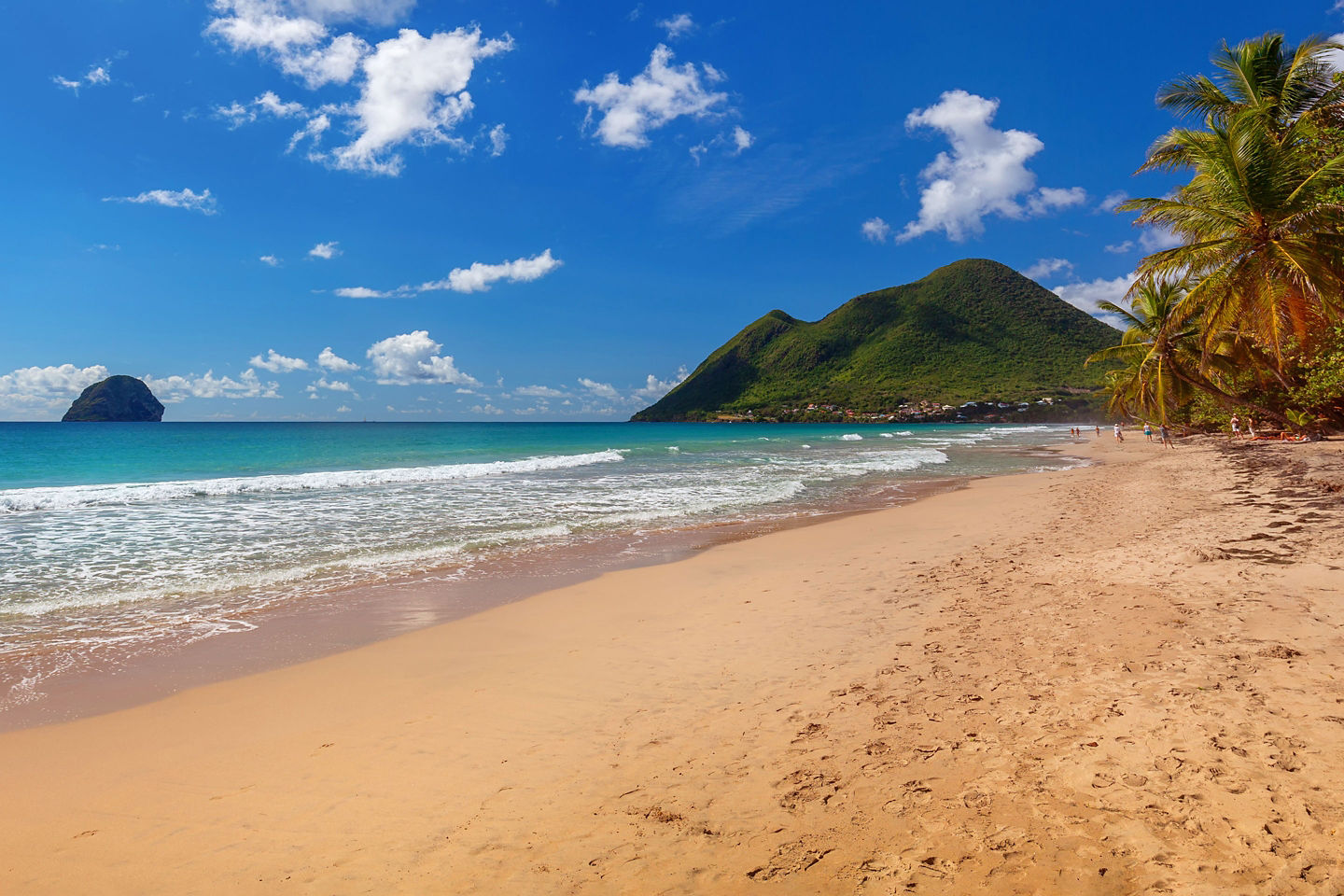 Le Diamant Beach curves along bright turquoise water with gentle waves meeting its soft white sand. - Fort-de-France, Martinique