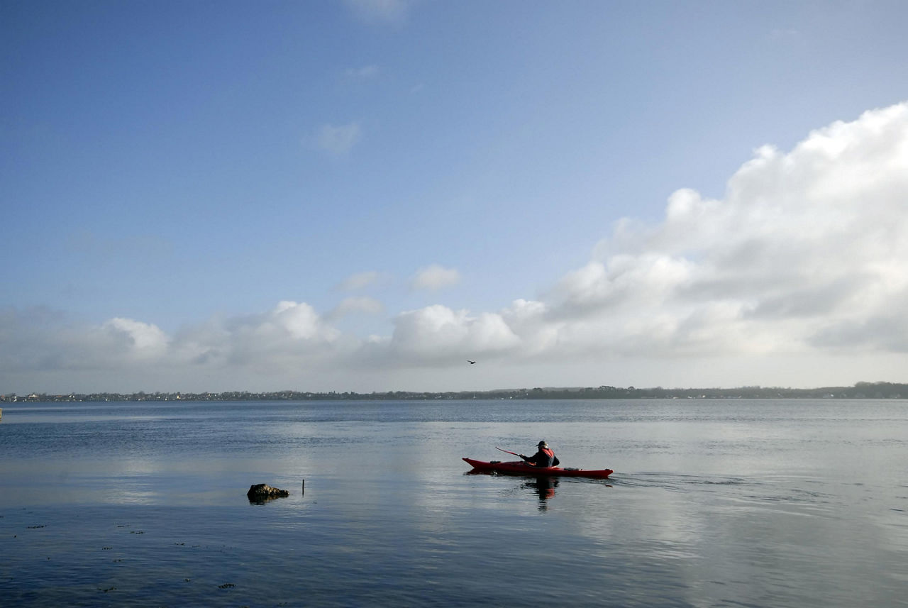 A person kayaking in the bay in Demark