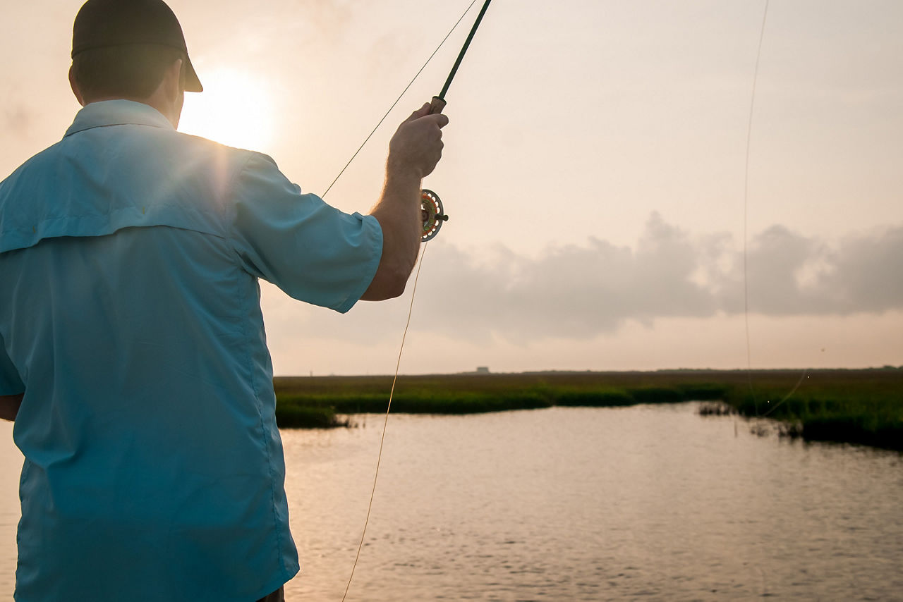 Man fly fishing at sunset in Galveston. Texas.