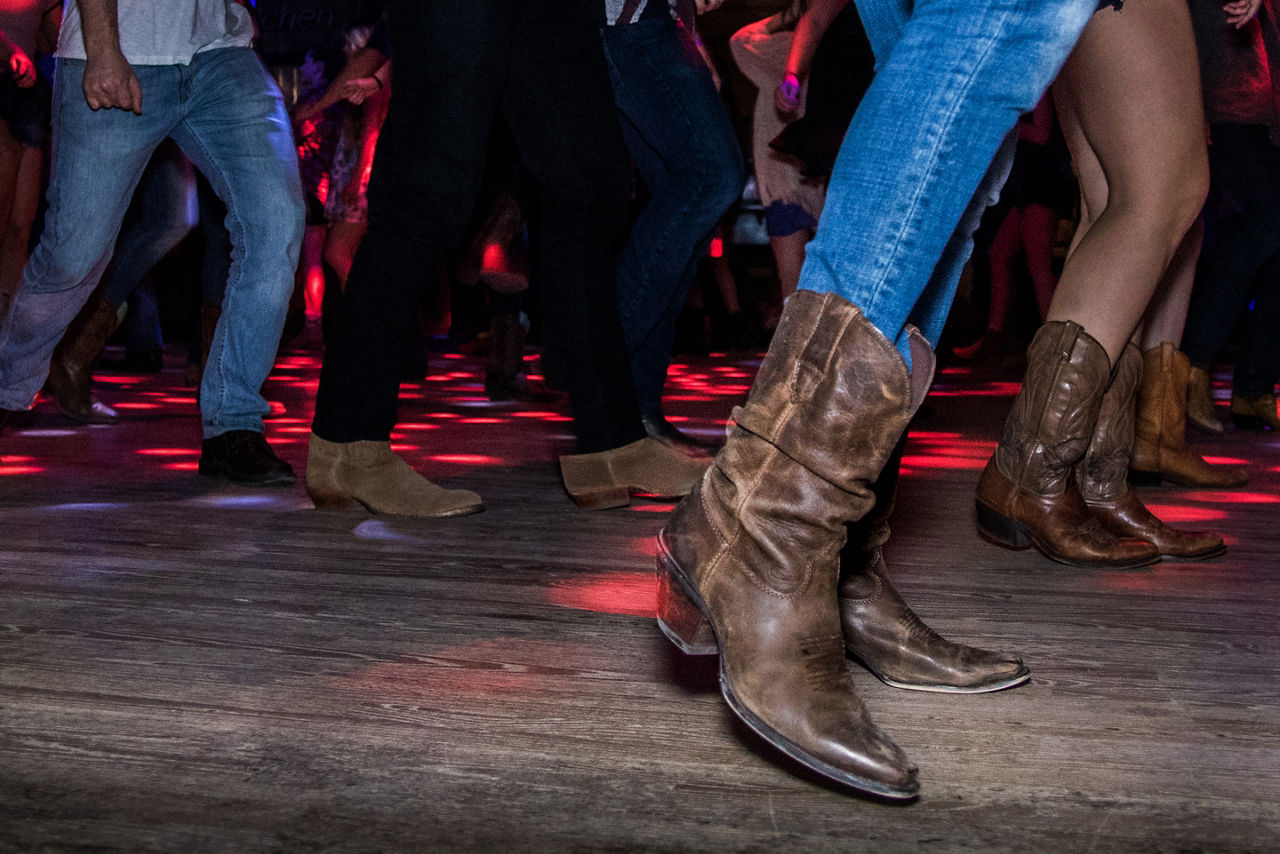 people line dancing together in cowboy boots. Galveston, Texas.