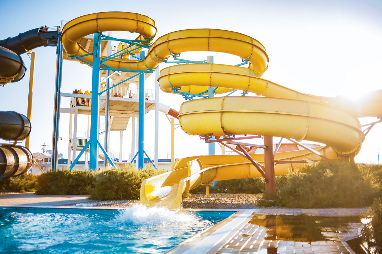 Yellow water slide straight to the pool.