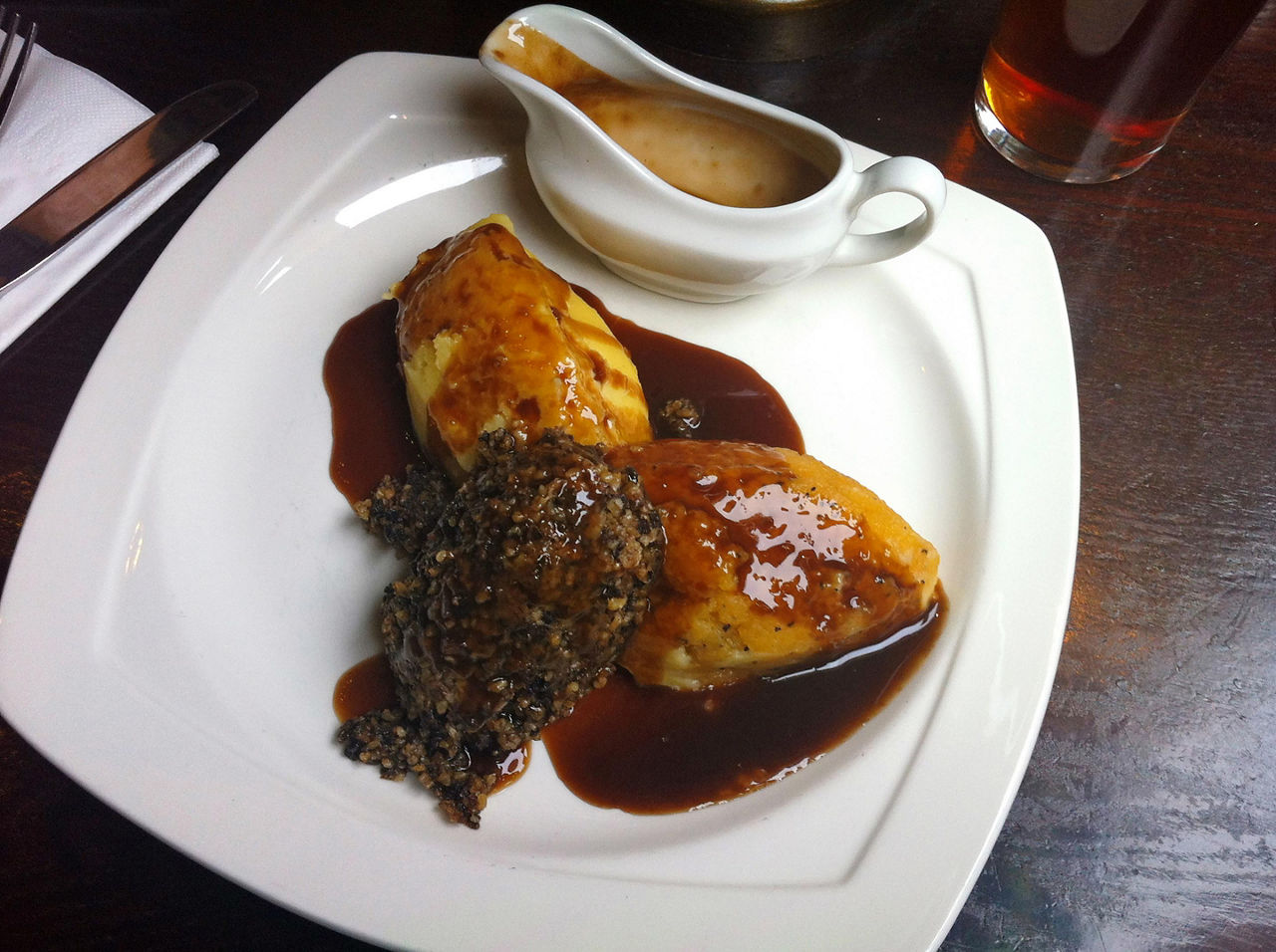 A white plate with haggis and gravy