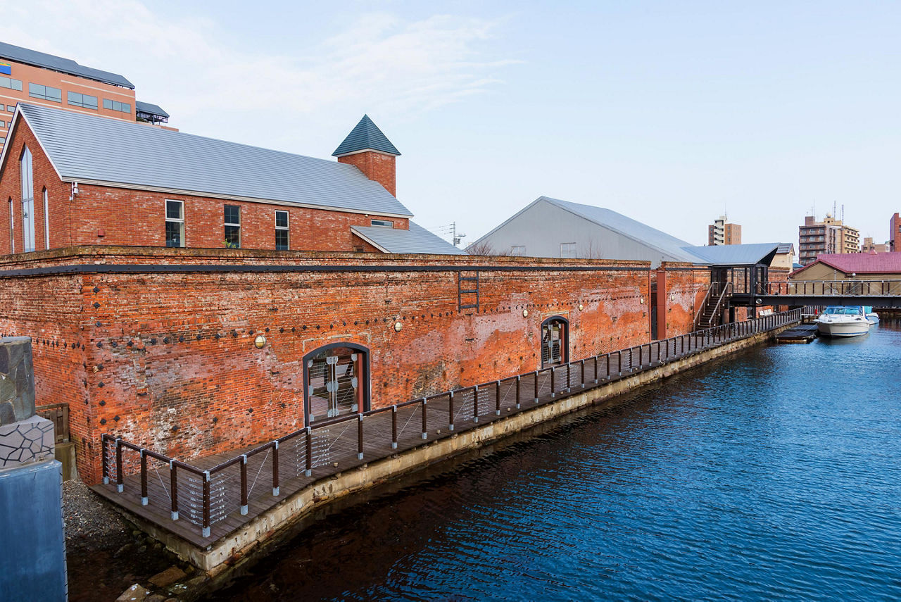 Kanemori red brick warehouse, bay-side godowns,  and ferry boat in Hakodate, Japan