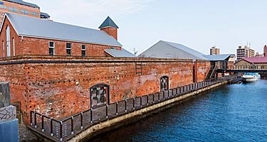 Kanemori red brick warehouse, bay-side godowns,  and ferry boat in Hakodate, Japan