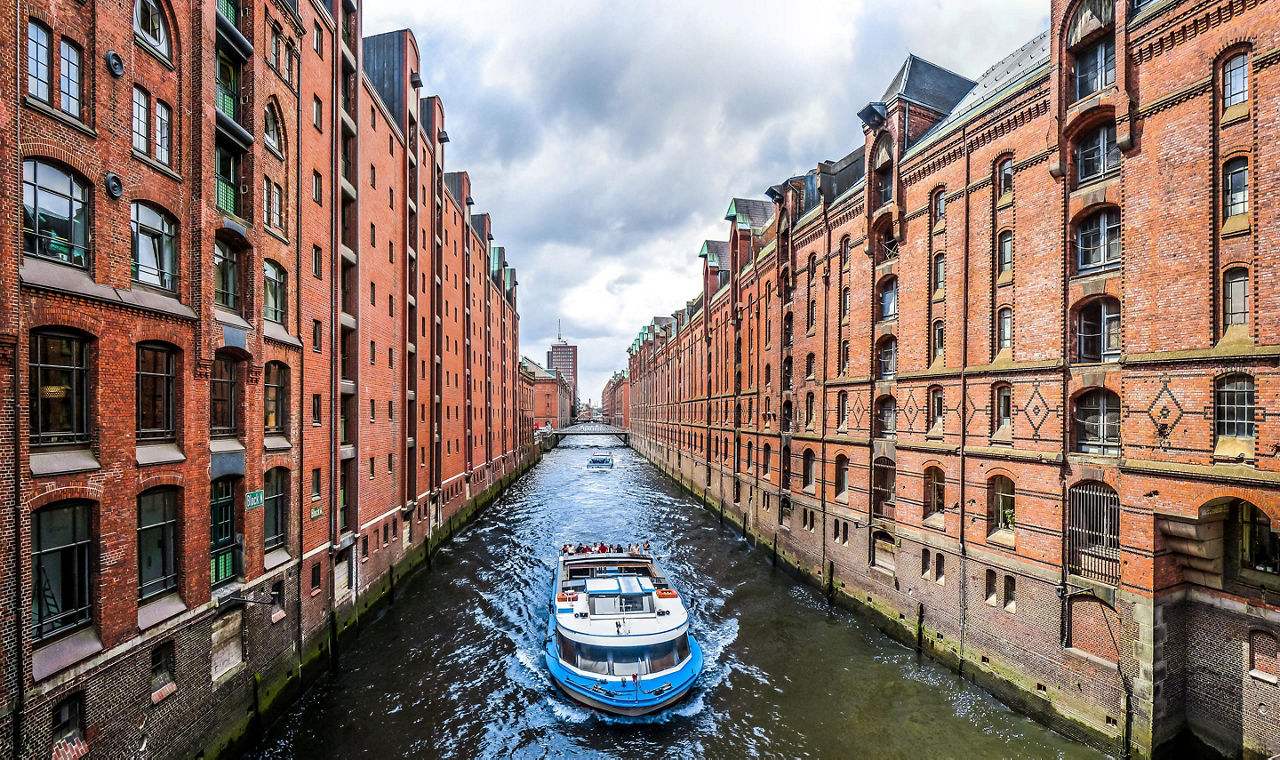 A boat traveling through a canal in the famous Speicherstadt warehouse district in Hamburg, Germany
