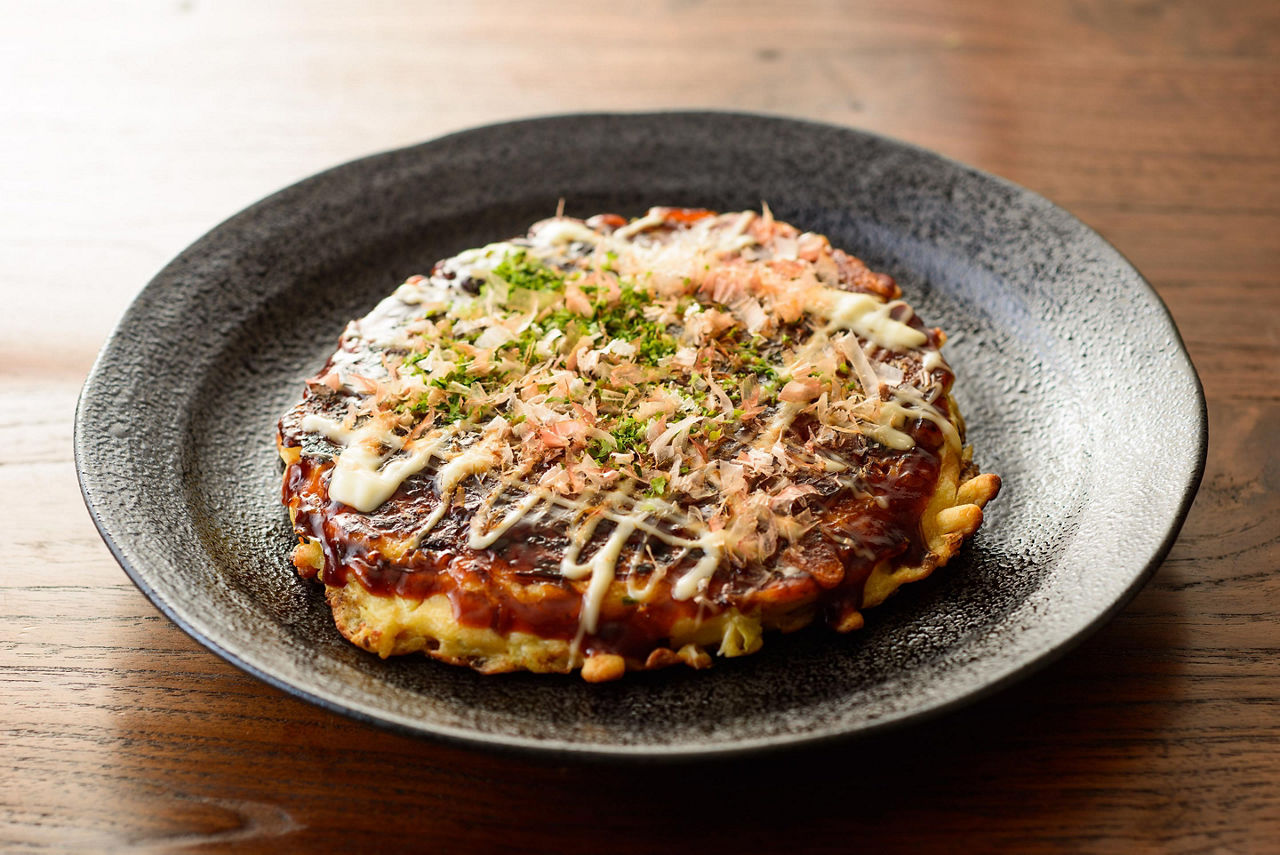 Japenese style pancakes known as Okonomiyaki drizzled with sauce