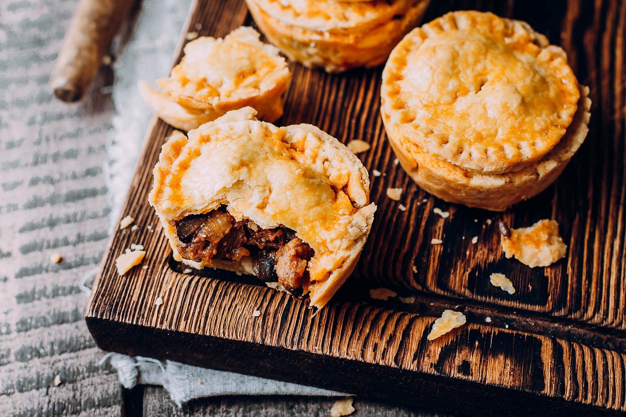 Fresh Traditional Australian meat mini pie on the wooden board on table background