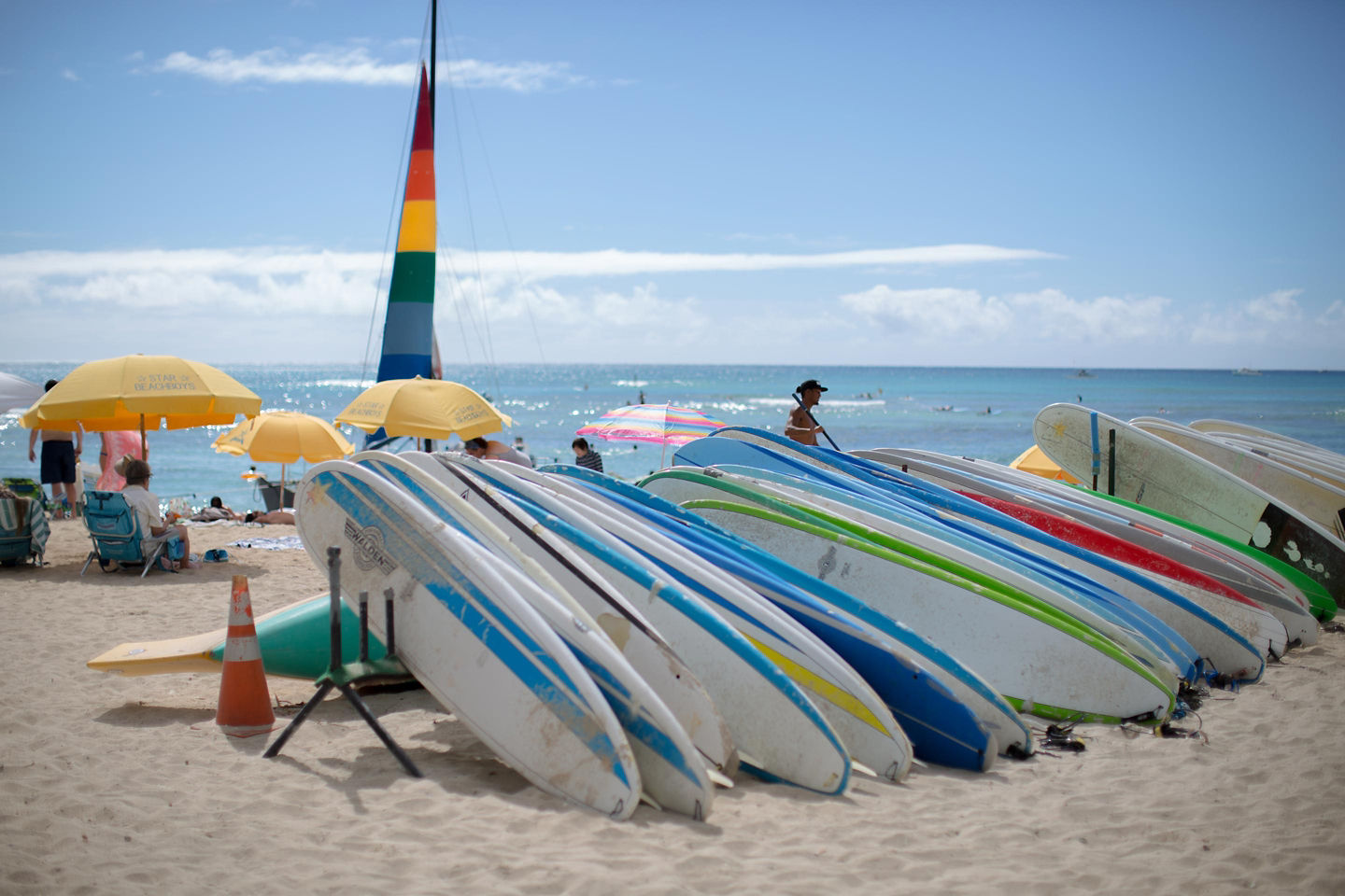 Colorful surfboards stand upright on Waikiki Beach, ready for surfers along Honolulu’s shoreline. - Honolulu, Hawaii