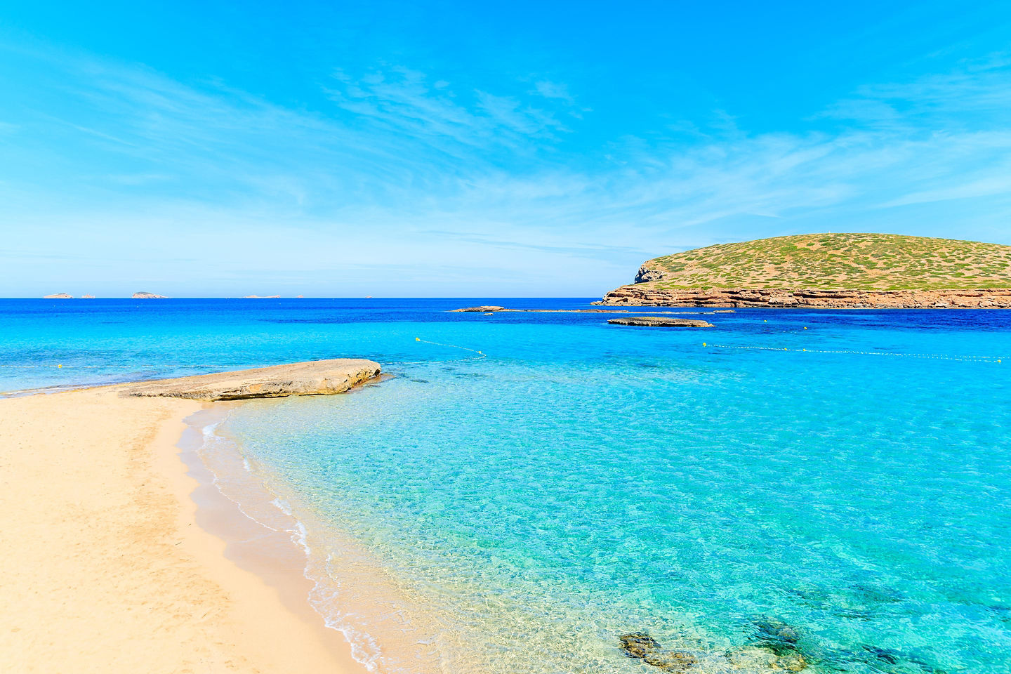 Cala Comte’s clear turquoise water meets pale sand along Ibiza’s bright Mediterranean shoreline. - Ibiza, Spain