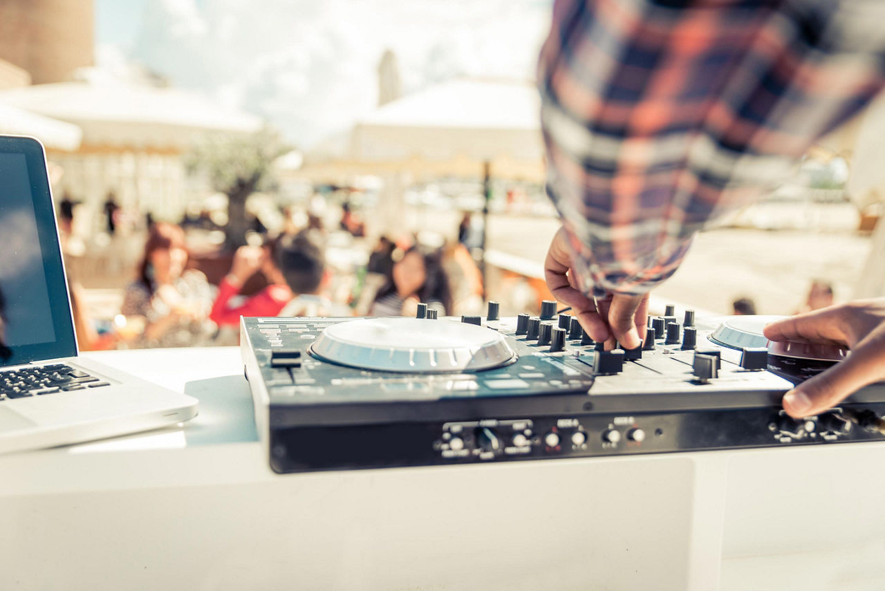 A close up view of a DJ's mixer during an outdoor party