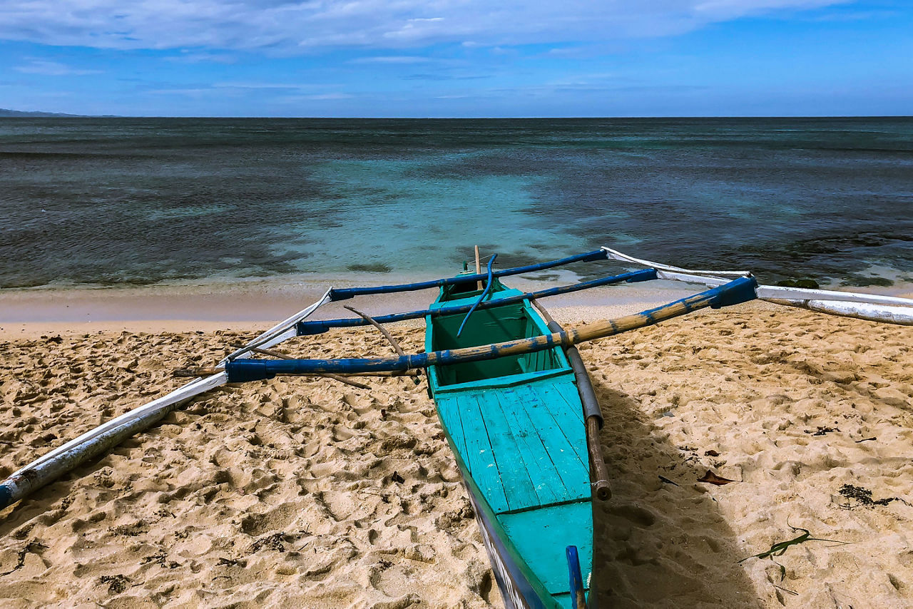 Blue boat docked by the shore in Ilocos, Philippines