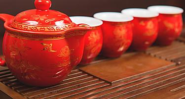 A red tea set with asian designs on a wooden platform in Taiwan