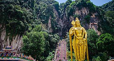 The Batu Caves with a gold statue of Lord Murugan at the entrance near Kuala Lumpur, Malaysia