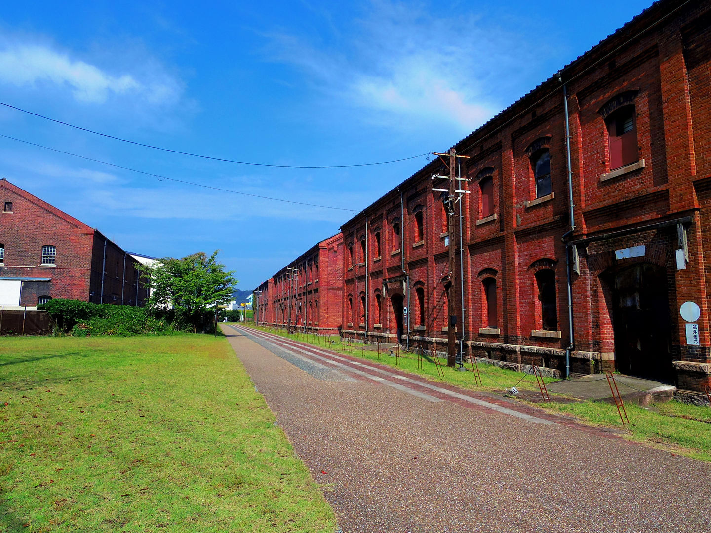 Maizuru’s Brick Museum features historic red‑brick warehouses with arched windows set against a clear sky. - Kyoto (Maizuru), Japan