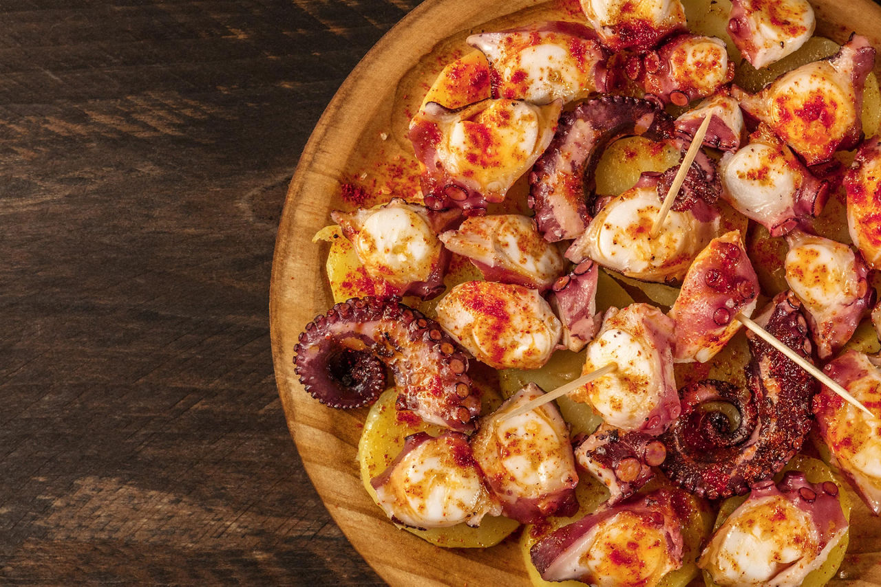 A plate with pulpo a la gallega, grilled octopus, and boiled potatoes