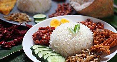 Nasi Lemak is a local cuisine in Langkawi, Malaysia consisting of rice with coconut cream, meats, and veggies