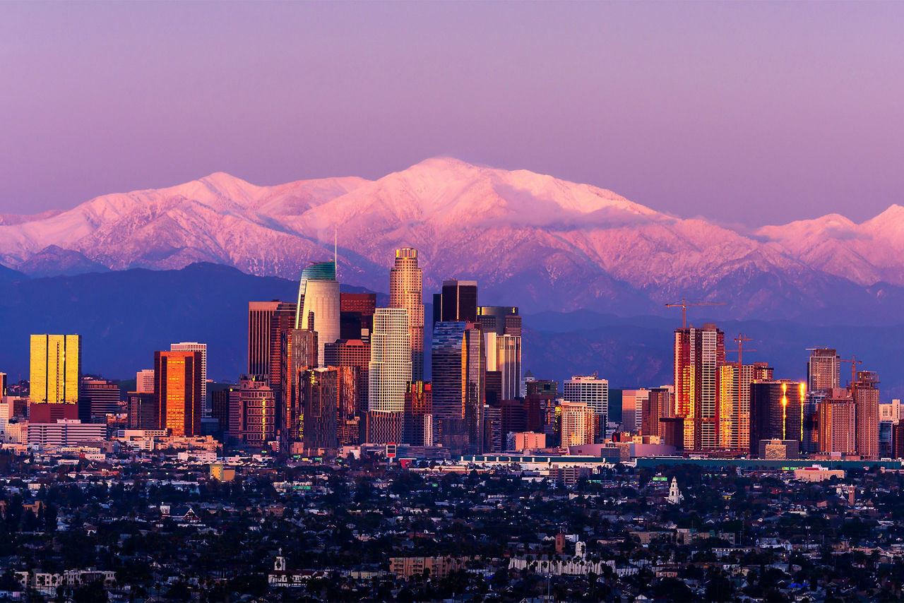 Skyline of LA with mountains behind the city at sunset. Los Angeles.