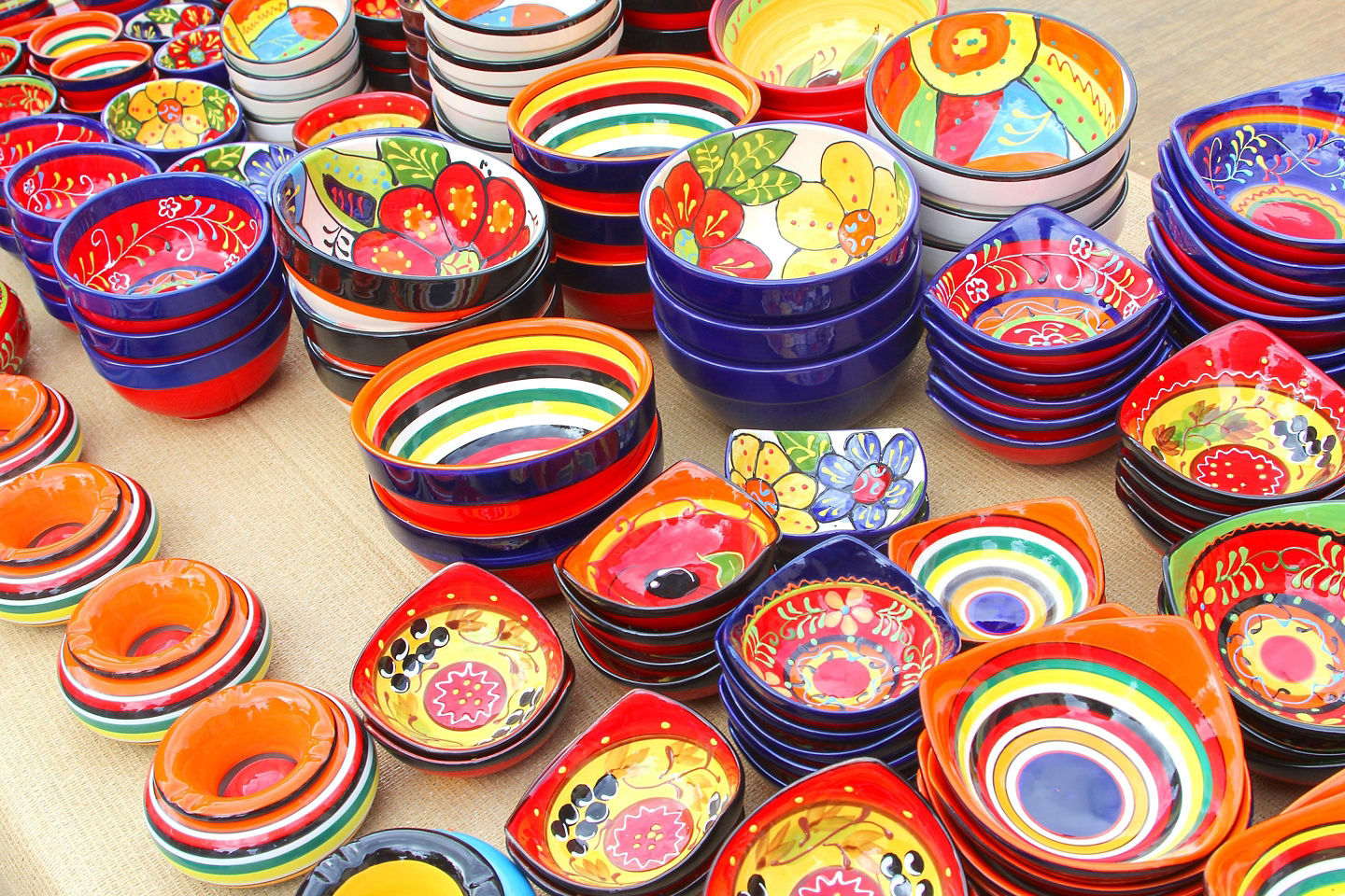 Colorful ceramic pottery in Málaga is arranged outside a shop, showcasing bright handcrafted designs. - Málaga, Spain