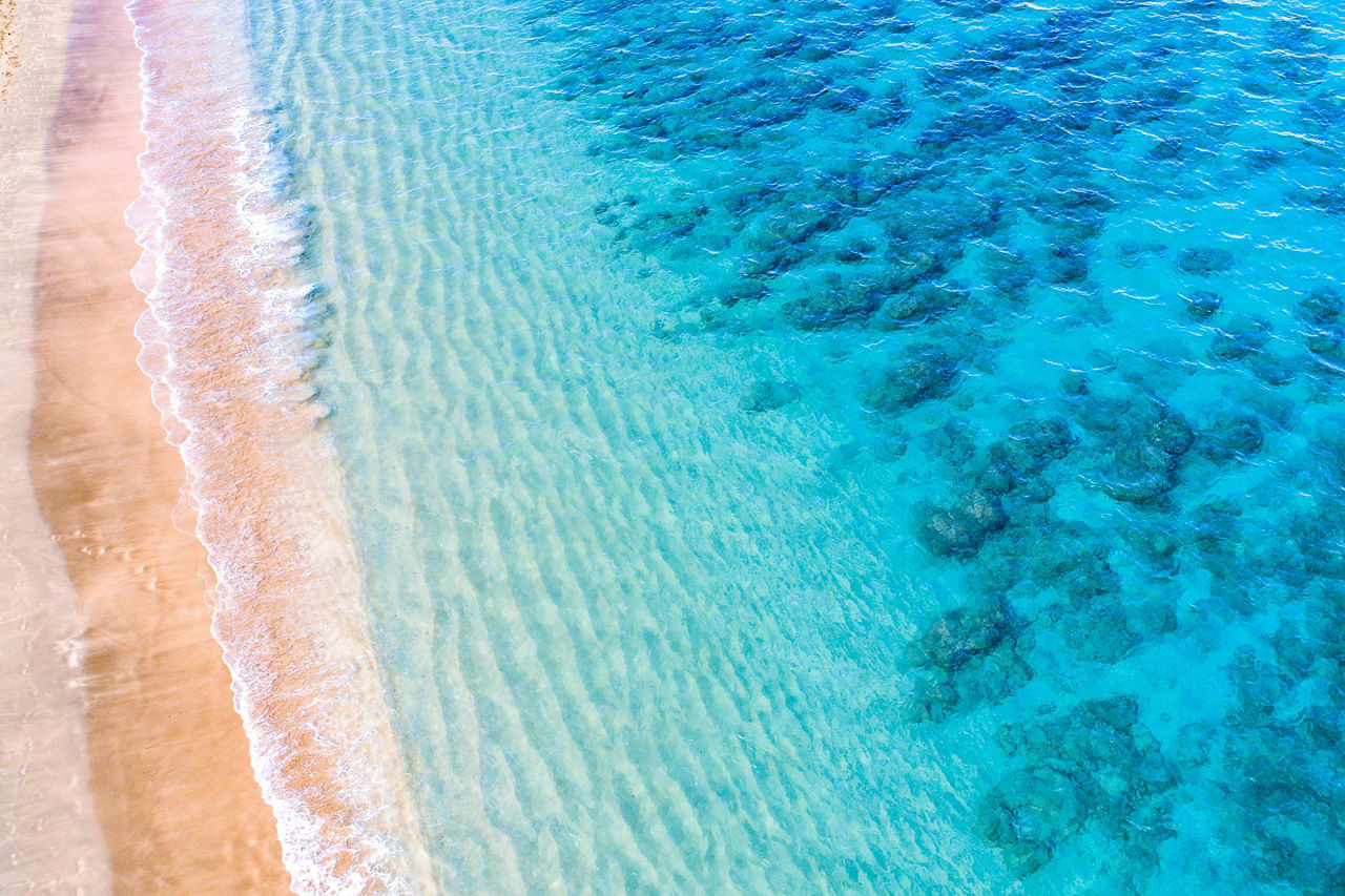An aerial view of a crystal blue beach and shoreline in Lahaina, Maui, Hawaii