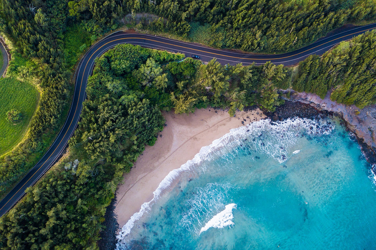 Aerial view of the sandy beach and curved asphalt road on the west coast of Maui Hawaii