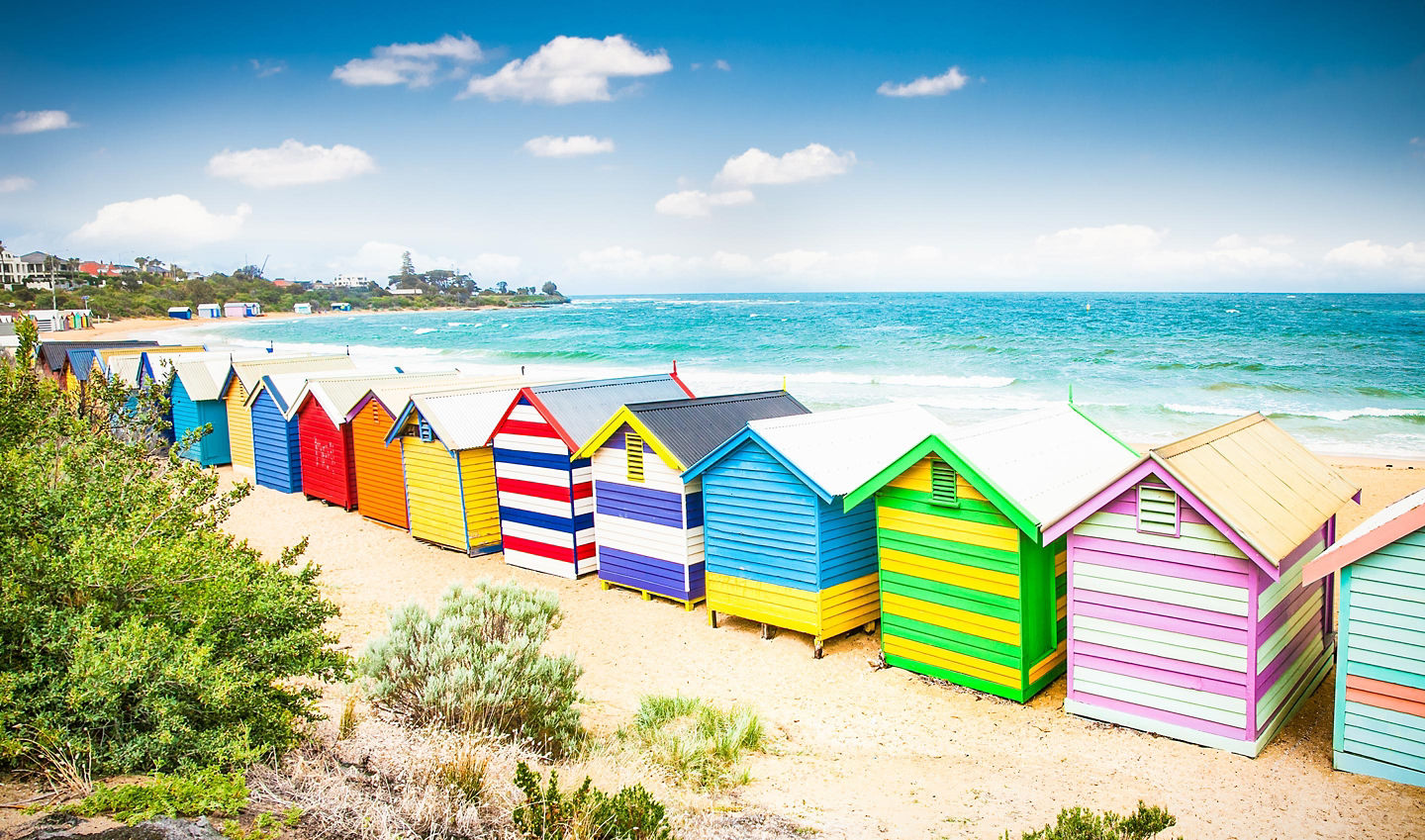 Colorful bathing houses on white sandy beach at Brighton beach in Melbourne.