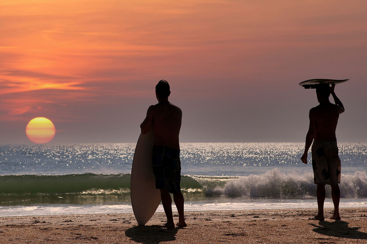 two surfers at Cocoa Beach during sunrise. Florida.