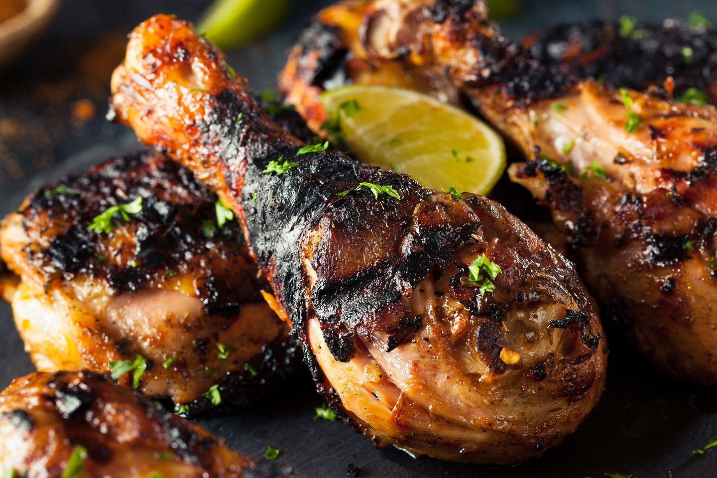 Jamaican jerk chicken drumstick served hot, showing charred seasoning. - Tortola, British Virgin Islands 