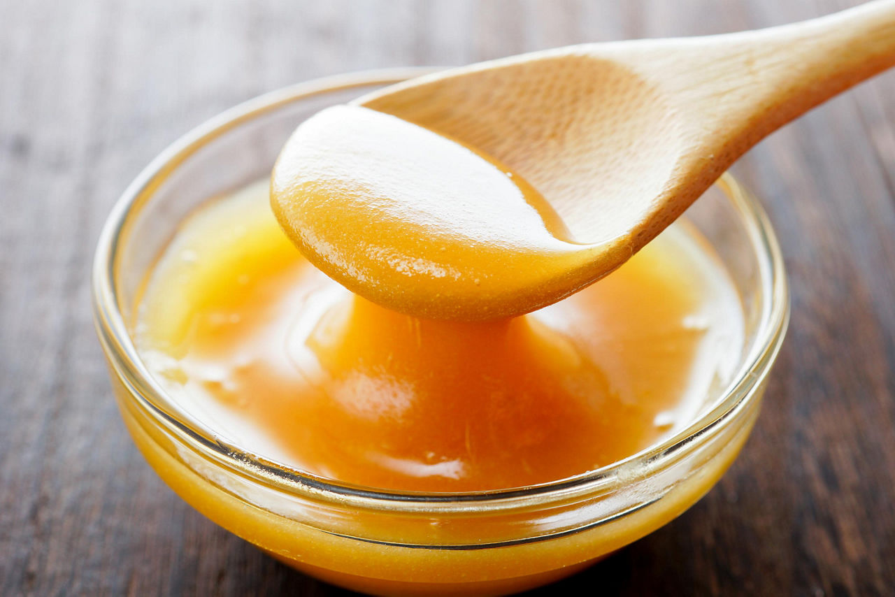 Manuka honey in a bowl with a wooden spoon