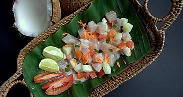 Polynesian authentic and famous dish -raw fish salad with cucumber, lime, tomato and coconut milk