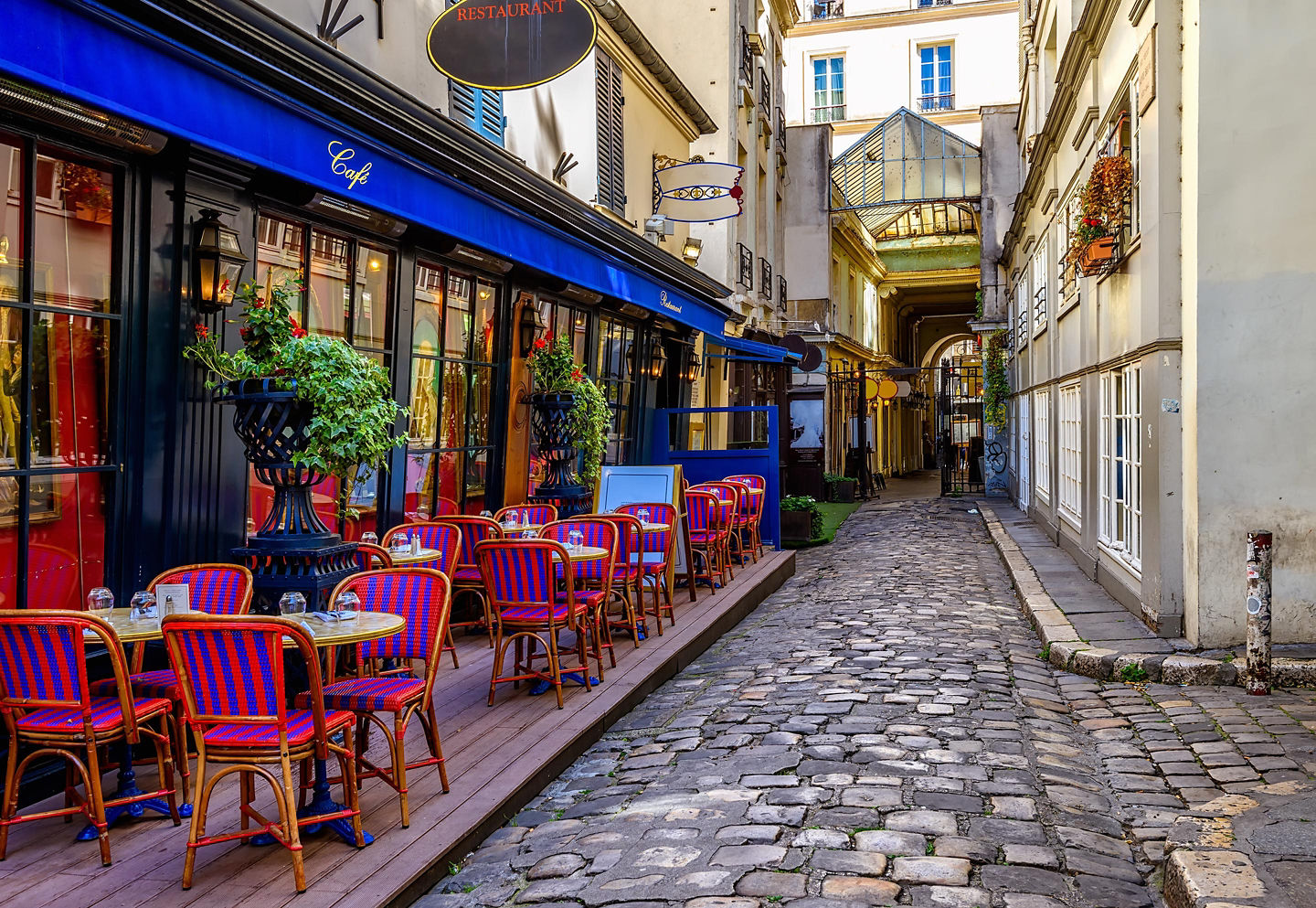 A classic Parisian café features outdoor tables, warm lighting, and a relaxed street‑side atmosphere. - Paris, France