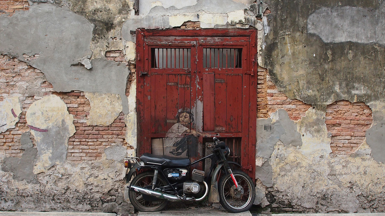 Street art of a boy riding a motorcycle in Penang, Malaysia