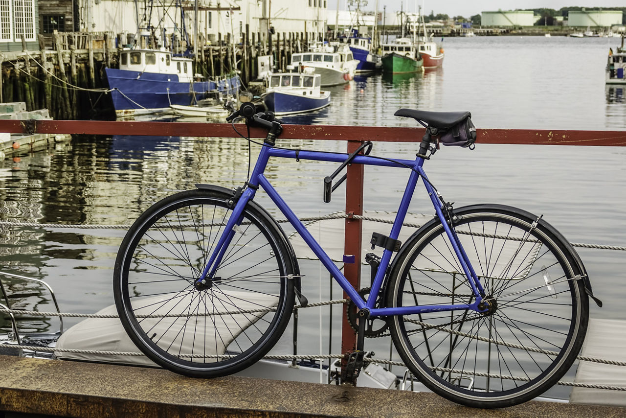 A bicycle locked to a railing at a harbor in Portland, Maine